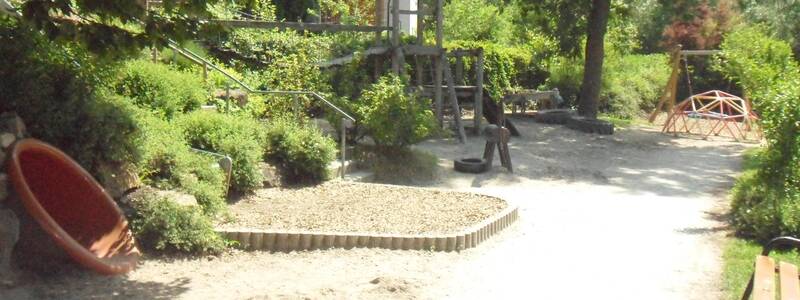 DRK Kita Filsblick Garten mit Klettergerüst und Schaukel im Hintergrund