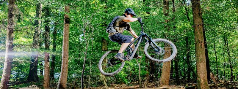 Ein Radfahrer bei einem Sprung mit deinem Mountainbike auf der Ebertrail Mountainbikestrecke