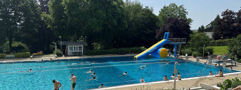 Schwimmerbecken des Ebersbacher Waldhöhenfreibades mit montierter aufblasbarer Rutsche am 3-Meter-Turm