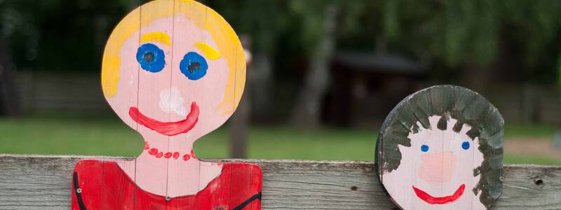 Holzfiguren auf einer Bank der Evangelischen Kinderkrippe Zwergenstüble