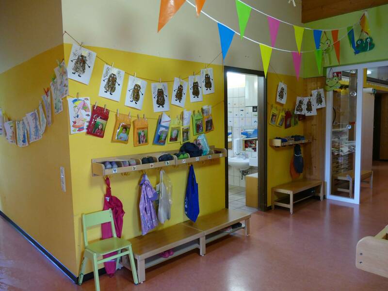 Flur im Kindergarten Sonnenschein Bünzwangen mit Garderobenbereich und bunten Bildern an einer gelben Wand